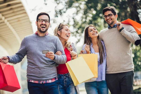 Amigos divirtiéndose en ir de compras juntos, sosteniendo bolsas de compras un — Foto de Stock