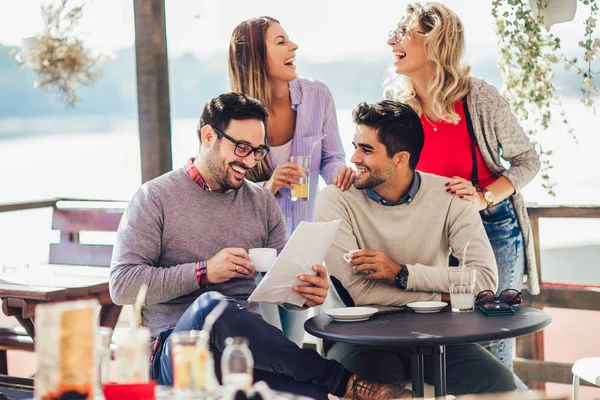 Grupo de cuatro amigos divirtiéndose tomando un café juntos. Dos mujeres un — Foto de Stock