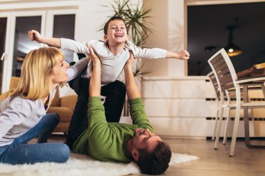 Evde oturma odasında yerde eğlenmek mutlu aile, rak