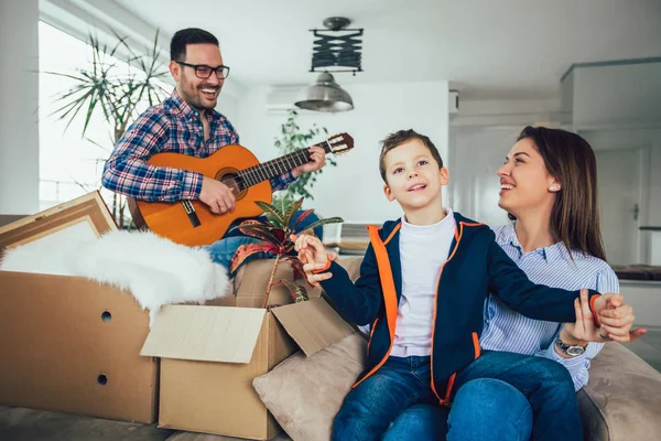 Happy family moving home with boxes around, and having fun. — Stock Photo, Image