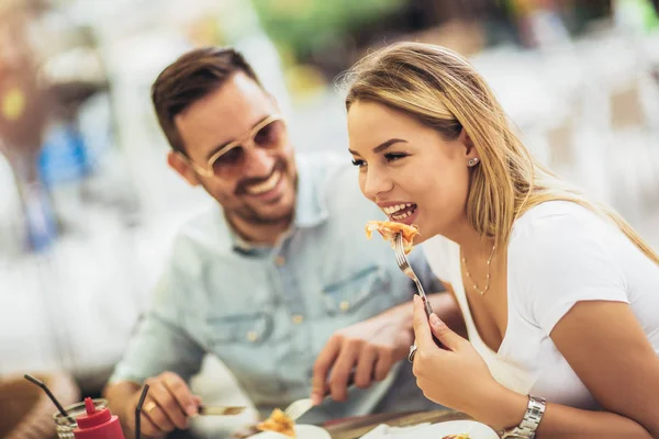 Et par pizzabudet utendørs. De deler pizza og... – stockfoto