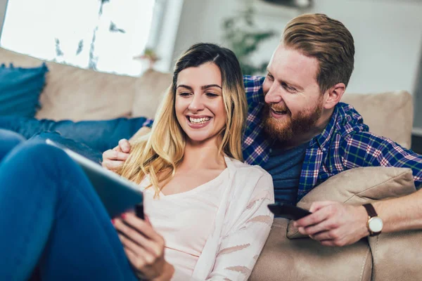 Çift kanepede oturan ve tablet eğleniyor, kullanma aşık.