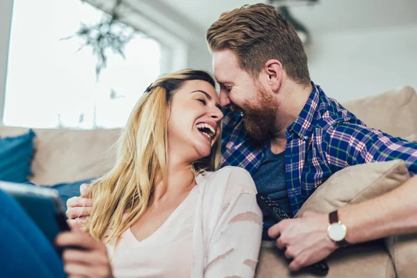 Çift kanepede oturan ve tablet eğleniyor, kullanma aşık.