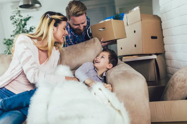 Happy family with cardboard boxes in new house at moving day. — Stock Photo, Image