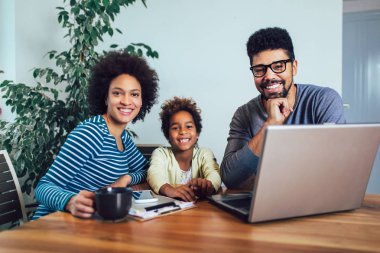 Afro-Amerikan aile oturma odasında dizüstü bilgisayar kullanarak.