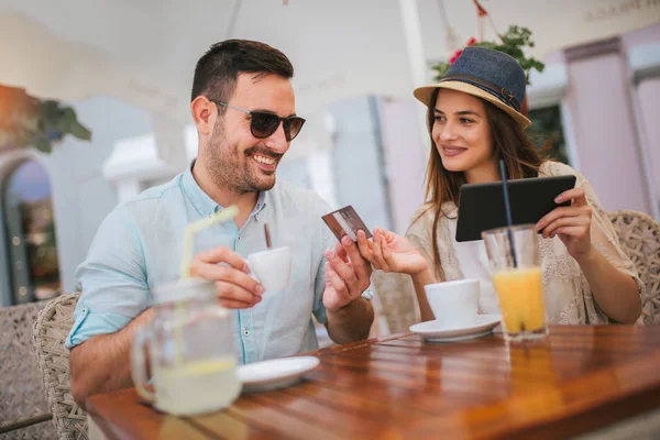 Feliz joven pareja de compras en línea mientras está sentado en un café . —  Fotos de Stock