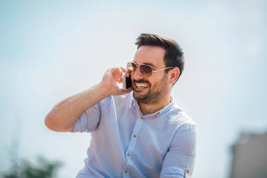 Yakışıklı adam cep telefonu çağrı gülümseme açık şehir sokak,