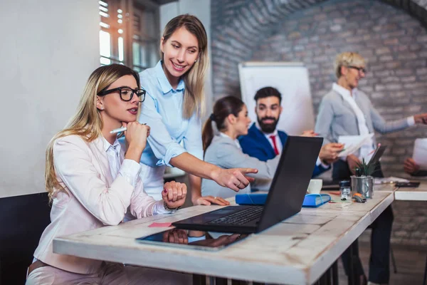 Los colegas de negocios que trabajan en el ordenador portátil en la oficina moderna. — Foto de Stock