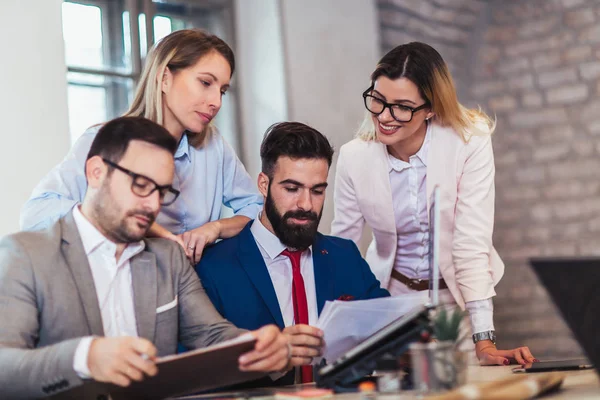 Los colegas de negocios que trabajan en el ordenador portátil en la oficina moderna. — Foto de Stock