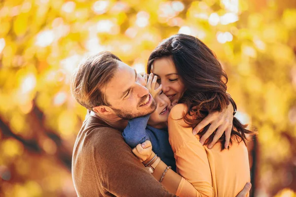 Giovane famiglia si diverte nel parco autunnale con suo figlio . — Foto Stock