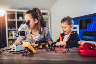 Mutlu gülümseyen erkek ve kız teknik oyuncak inşa eder ve soymak yapmak