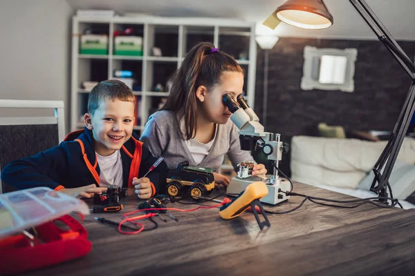 Happy smiling boy and girl constructs technical toy and make rob — Stock Photo, Image