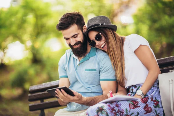 Lyckligt par tittar på media i ett digitalt bord utomhus — Stockfoto