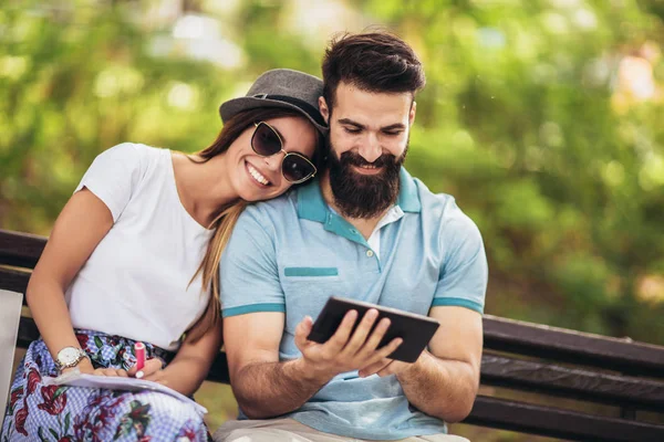 Lyckligt par tittar på media i ett digitalt bord utomhus — Stockfoto
