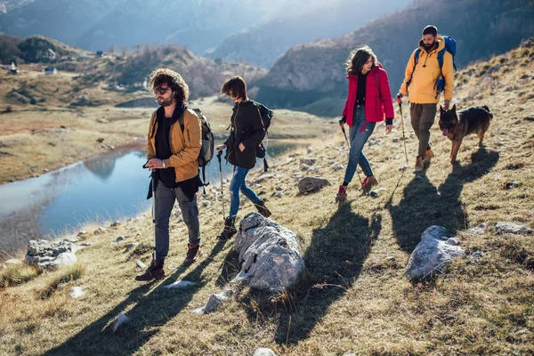 Group of hikers walking on a mountain at autumn day