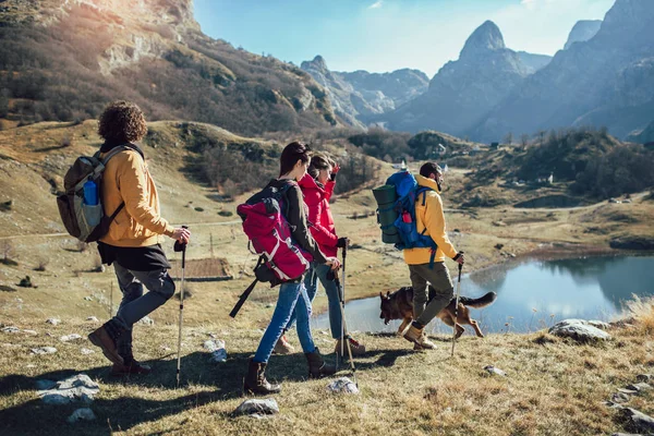 Group of hikers walking on a mountain at autumn day