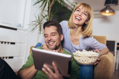 Oturma odasındaki kanepede oturan genç çift...