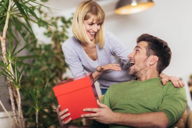 Mutlu adam otururken kız arkadaşı bir hediye alan 