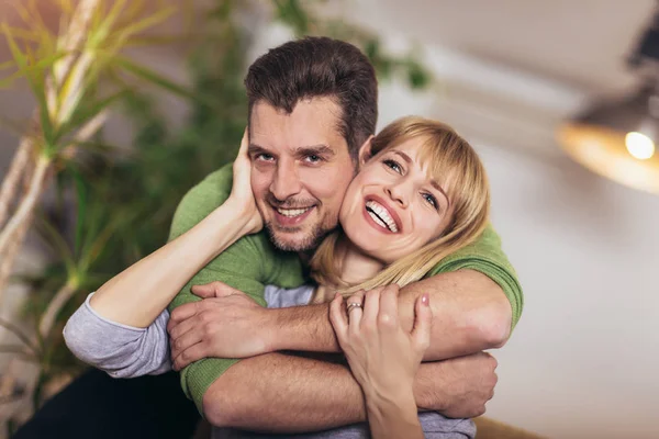 Loving young couple hugging and relaxing on sofa at home — Stock Photo, Image