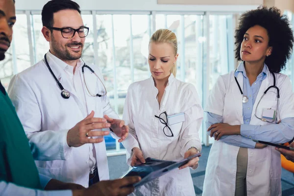 Doctor holding up an x-ray with fellow doctors — Stock Photo, Image