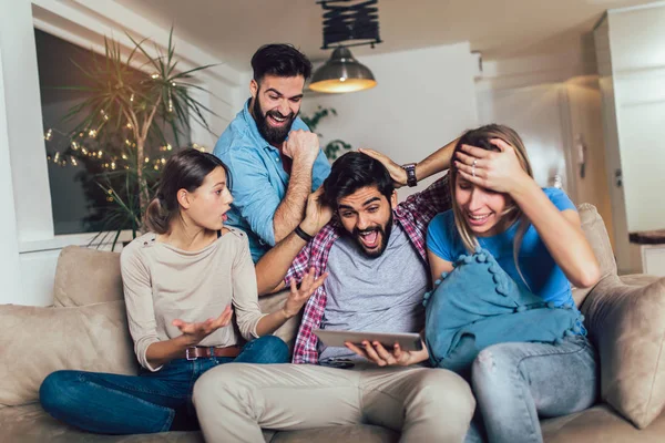 Cuatro amigos felices casuales riendo compras en línea juntos en un —  Fotos de Stock