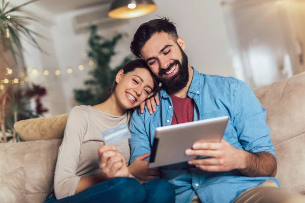 Χαμογελαστά ζευγάρι χρησιμοποιώντας ψηφιακό tablet και πιστωτικής κάρτας στο σπίτι — Φωτογραφία Αρχείου
