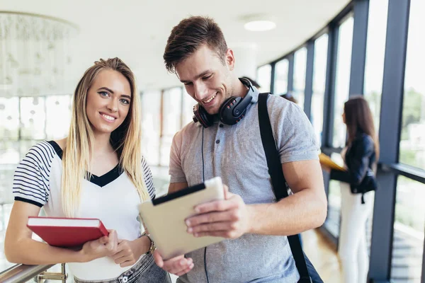 Dos estudiantes que utilizan la tableta digital en una universidad . — Foto de Stock