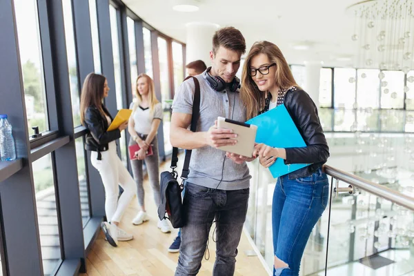 Dos estudiantes que utilizan la tableta digital en una universidad . — Foto de Stock