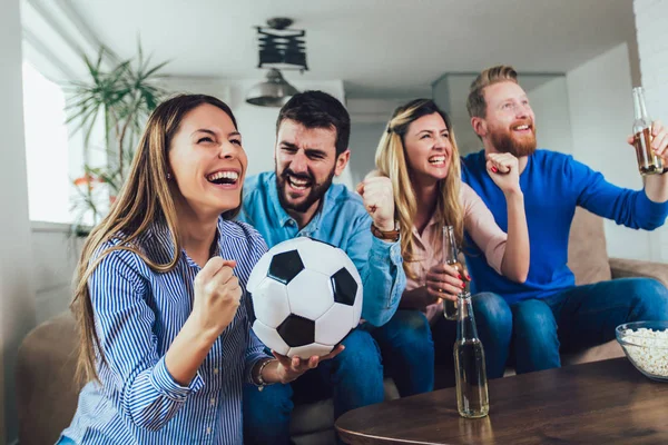Glada vänner eller fotbollsfans titta på fotboll på tv och personer — Stockfoto