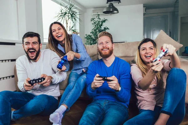 Группа друзей вместе играют в видеоигры дома, веселятся. — стоковое фото