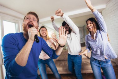 Evde karaoke oynayan arkadaş grubu. Kavram friendsh hakkında