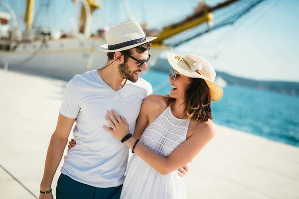 Glückliches junges Paar beim Spaziergang am Hafen eines touristischen Meeres-Resos — Stockfoto