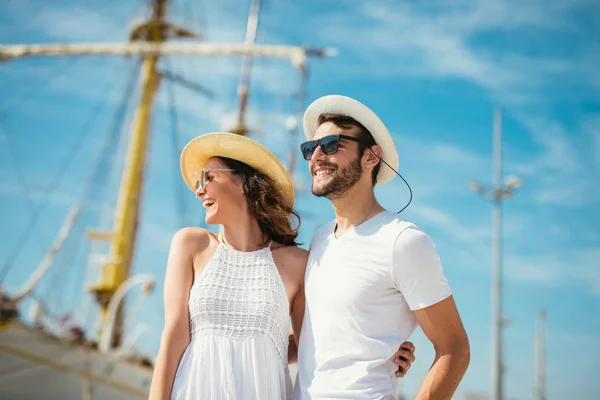Felice giovane coppia passeggiando al porto di un mare turistico reso — Foto Stock