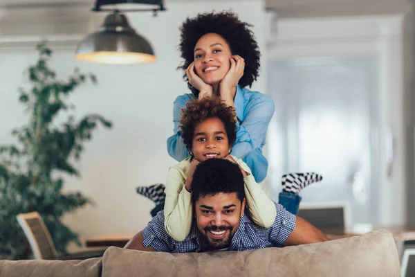 Щаслива сім'я позує на дивані разом вдома в живих — стокове фото