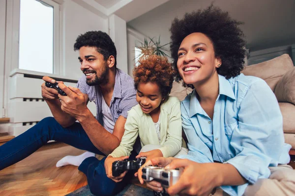 Aile birlikte video oyunları oynarken kanepede oturan gülümseyen