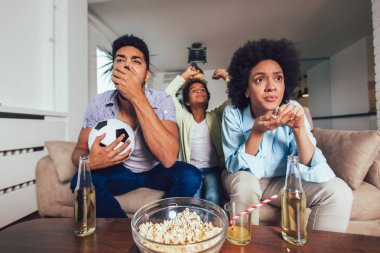 Üç Mutlu Afro-Amerikan aile tv izlerken ve tezahürat 