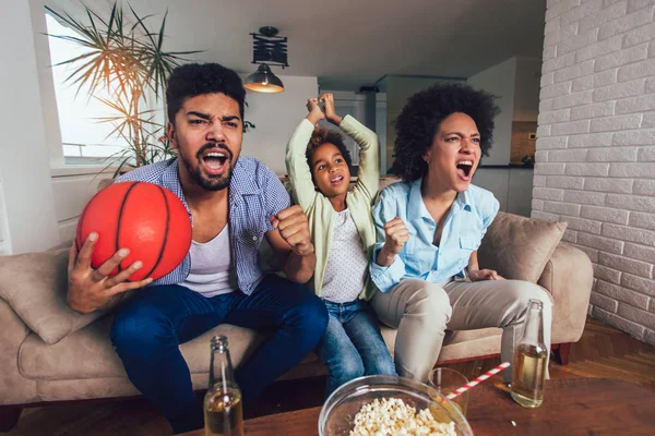 Feliz família afro-americana de três assistindo tv e torcida — Fotografia de Stock