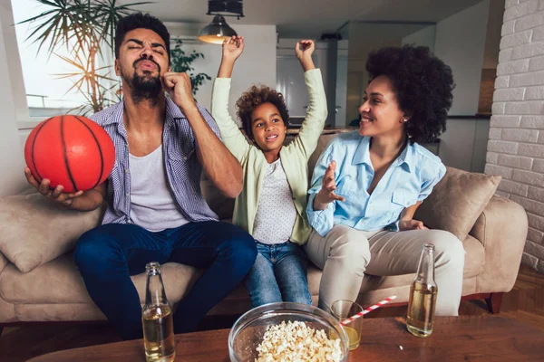 Felice famiglia afroamericana di tre guardare la tv e tifo — Foto Stock