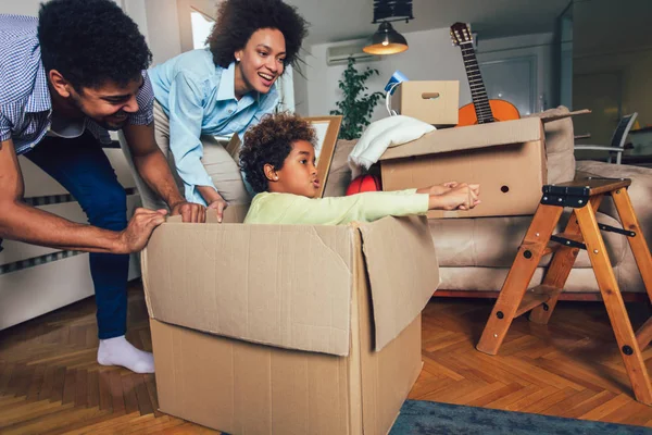 African American family, parents and daughter, unpacking boxes a — Stock Photo, Image