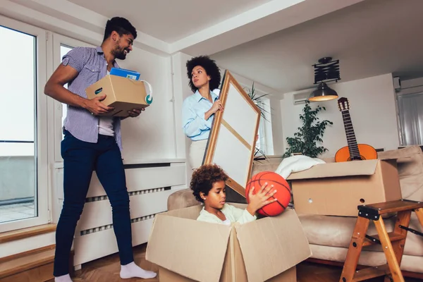 Afro-americano família, pais e filha, desempacotando caixas um — Fotografia de Stock