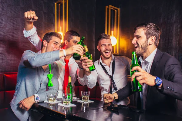 Gruppe junger Männer prostet sich in einem Nachtclub zu — Stockfoto