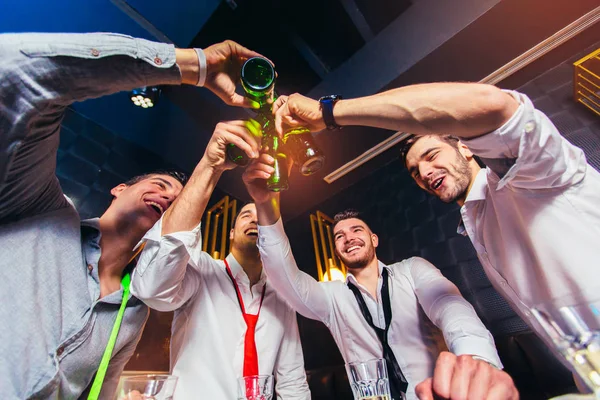 Group of young men toasting at a nightclub — Stock Photo, Image