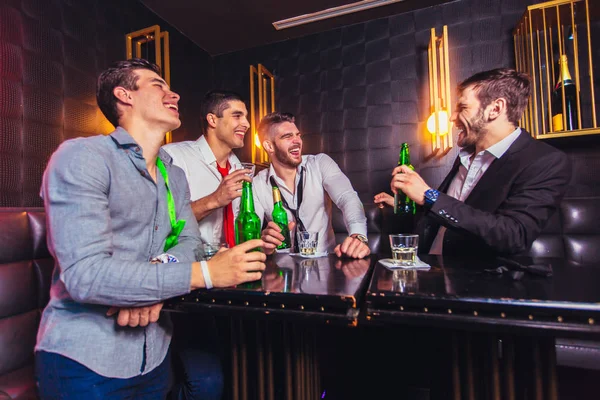 Группа улыбающихся друзей-мужчин веселится в ночном клубе — стоковое фото