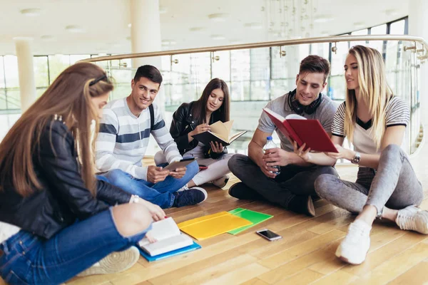 Fellow students sitting on floor in campus and preparing togethe — Stock Photo, Image