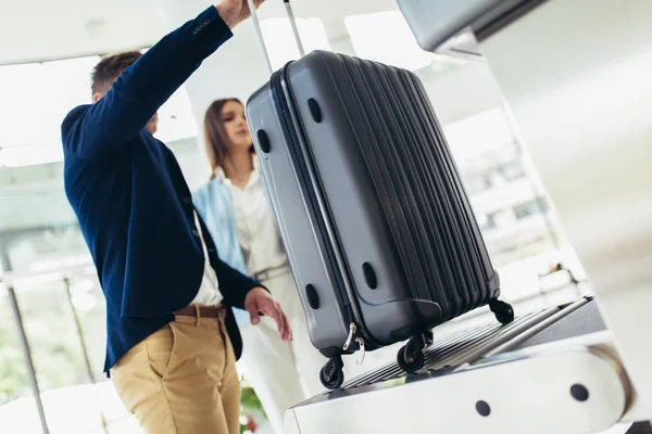 ビジネス旅行者は、X線装置に手荷物を置き、検出しようとする — ストック写真