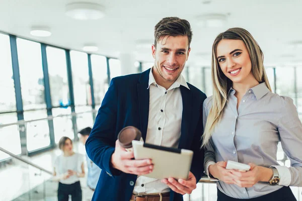 Mooie zakenvrouw en man die een Tablet in hun handen houden — Stockfoto