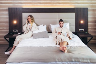 Bir kadın otel odasından yemek için oda servisini arıyor. 