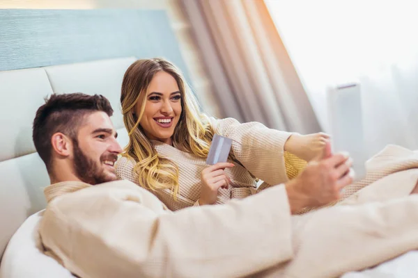 Joven pareja feliz compras en línea en habitación de hotel de lujo . — Foto de Stock