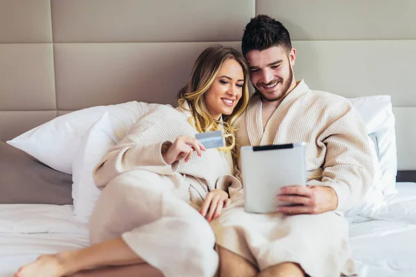 stock image Young happy couple shopping online in luxury hotel room. 