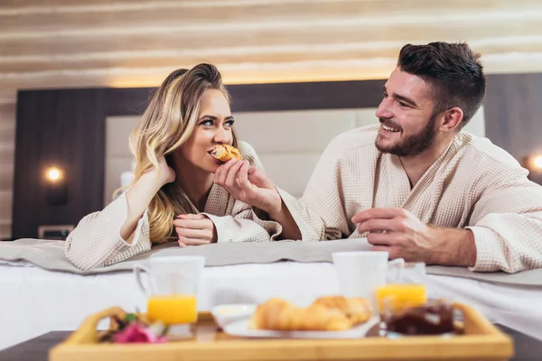 Молодая счастливая пара завтракает в роскошном номере отеля . — стоковое фото